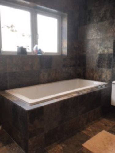 bathtub and brown tiles 